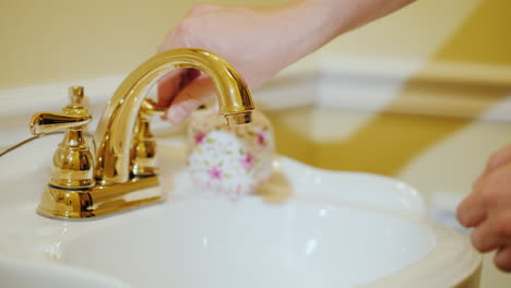 a man washes his hands under a tap with water