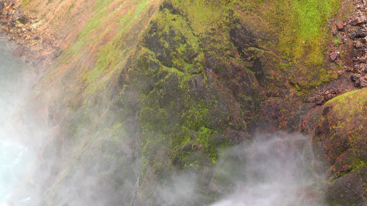 la niebla de las cataratas superiores de yellowstone golpea contra el acantilado cubierto de musgo