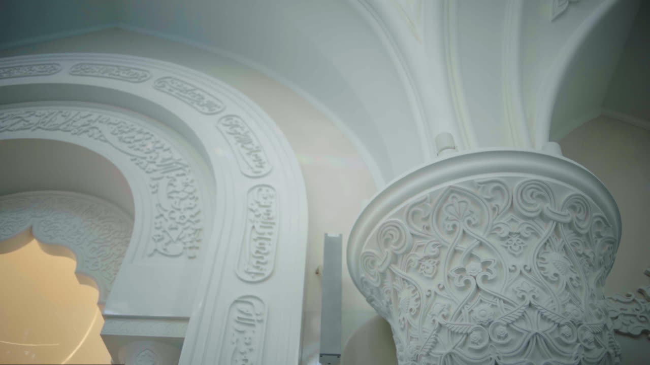 interior blanco de una mezquita con tallas y arcos intrincados