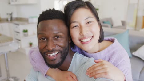 portrait of happy diverse couple having video call in living room