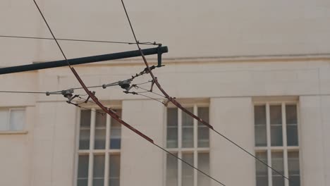 overhead trolley wire cables against coimbra university building with window backdrop