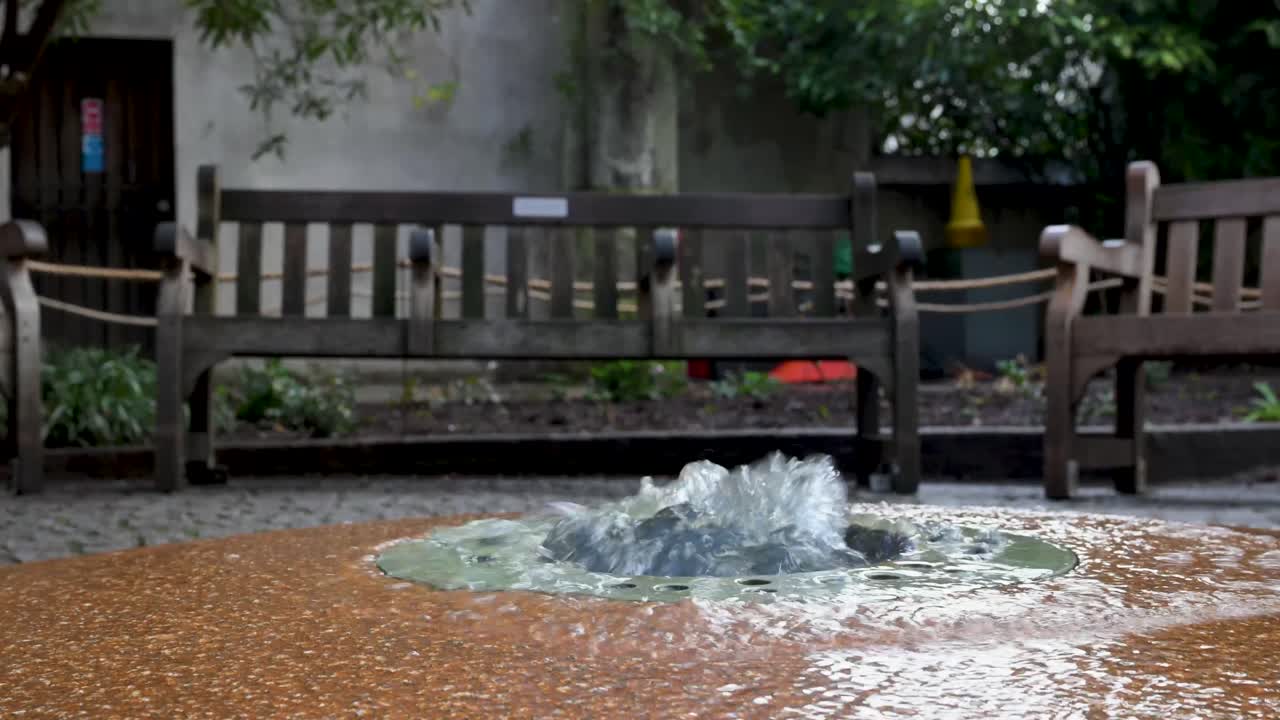 A peaceful water fountain feature situated within the gothic stone ruins and lush climbing ivy of the St Dunstan in the East church garden in the City of London