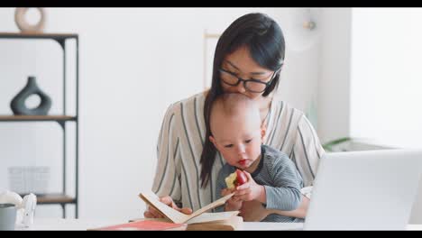 mother and baby at home, working and reading