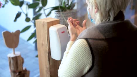 A-female-person-wearing-a-face-mask-disinfects-her-hands-in-the-hotel-lobby---Coronavirus-tourism-footage