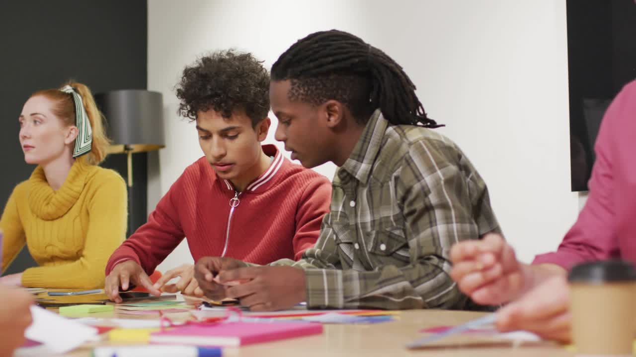 Art workshop participants sorting and cutting shapes while timed social prompts popping then fading