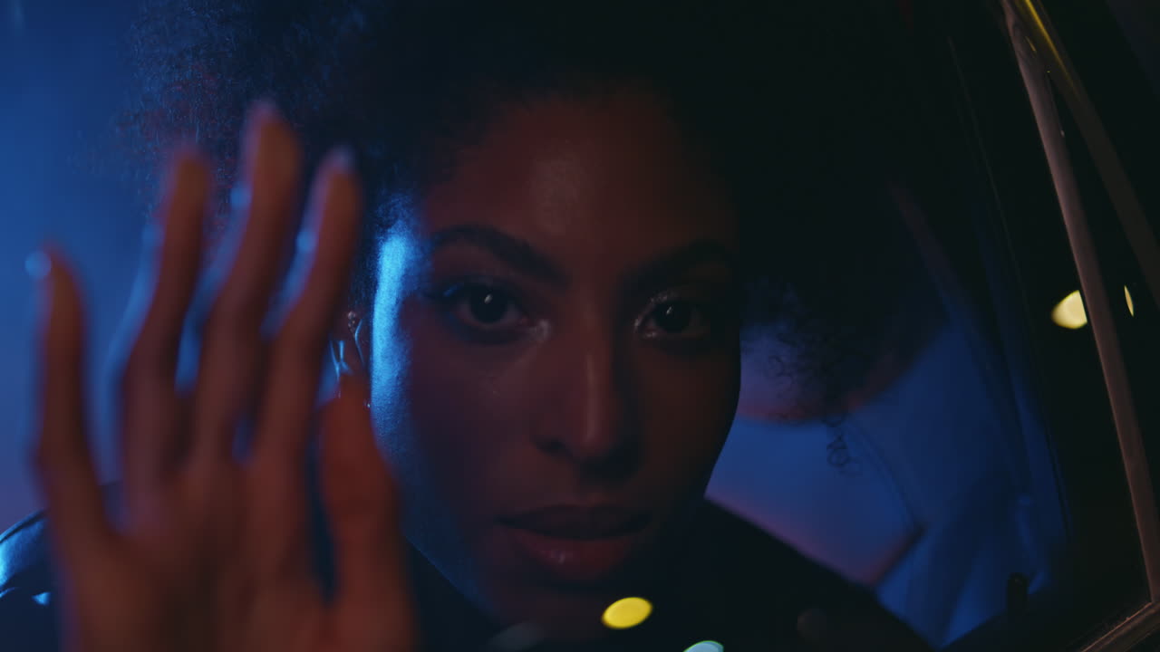 Night woman sitting automobile backseat looking through window in camera closeup