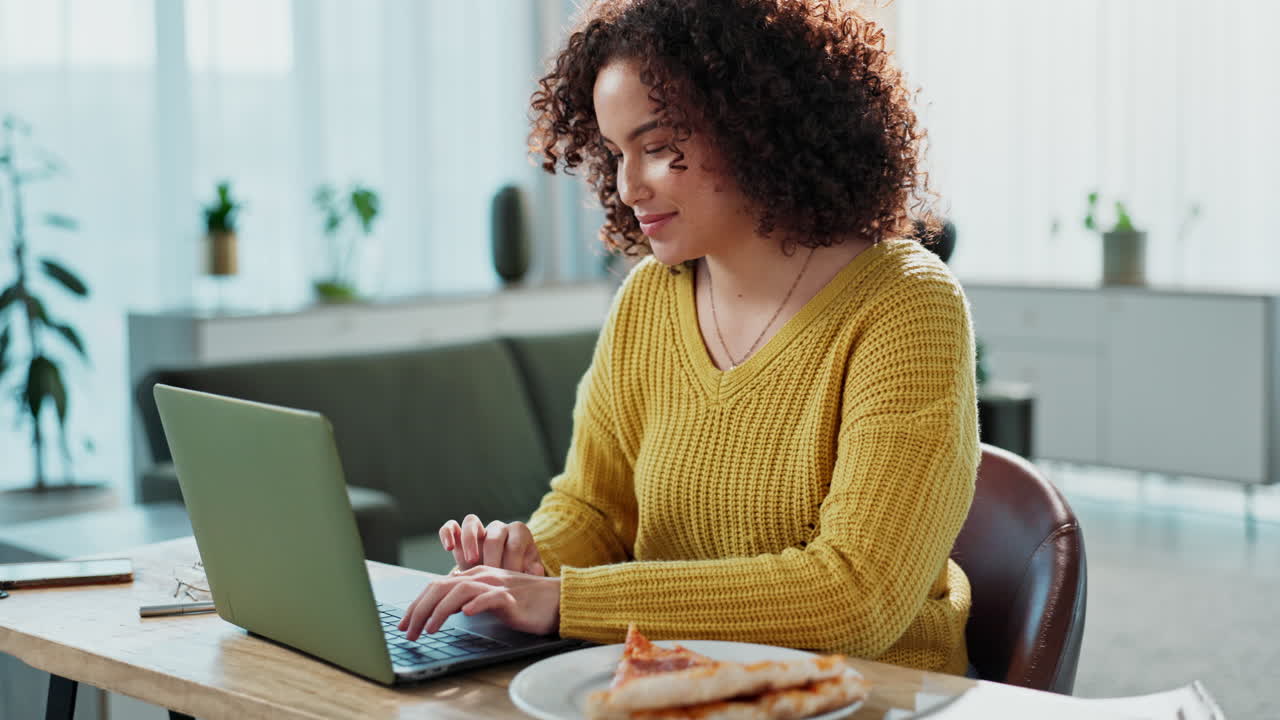 Woman working on laptop and eating pizza at home