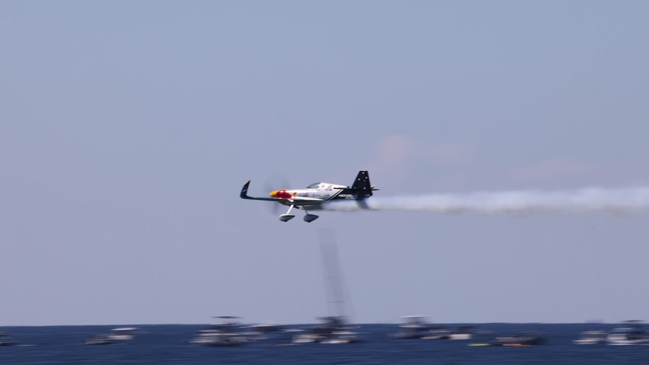 두 개의 다채로운 비행기가 연기 트레일로 날고 있습니다.