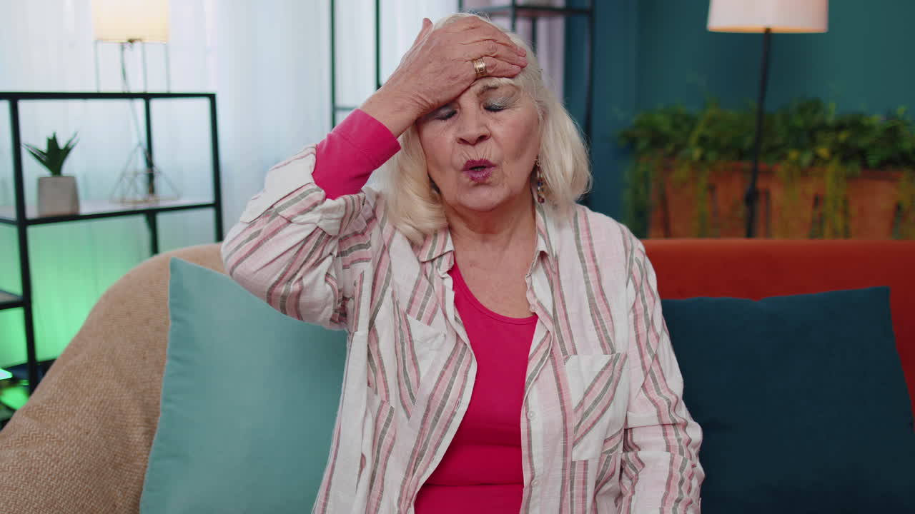 Upset senior old woman making face palm gesture, feeling bored, disappointed in result, bad news