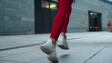 close up female legs jogging on urban street. athlete woman legs running outdoor