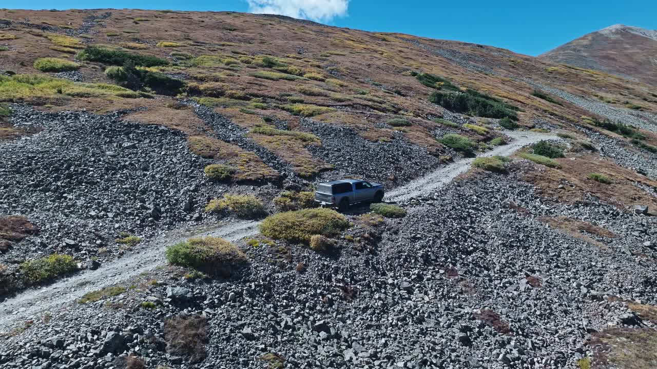 Rearview to sideview orbit as truck bounces along dirt road on Peak 10 trail Breckenridge Colorado