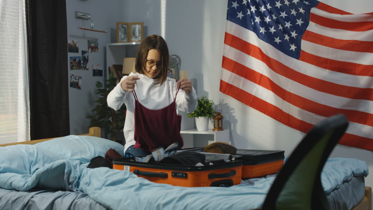 Teenage girl packing a suitcase in her bedroom