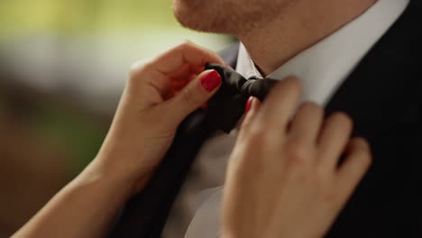 Woman-hands-getting-better-bow-tie-outdoors.-Couple-standing-before-ceremony