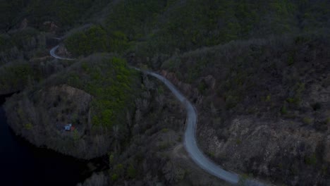 Aerial-pull-back-over-road-in-the-forest-during-stormy-winter-day