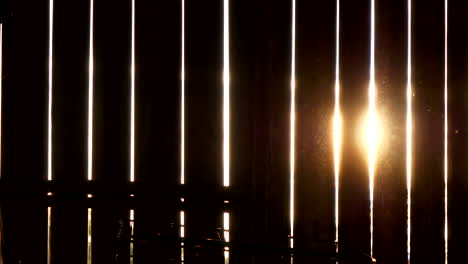 sunlight beam shines through gaps of barn wall in rural area