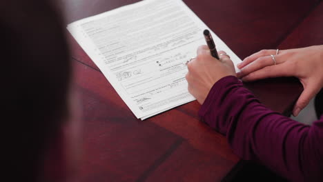 pareja joven firmando documentos legales en una oficina