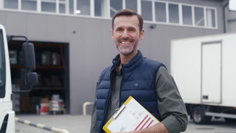 portrait of caucasian mature man in front of warehouse.