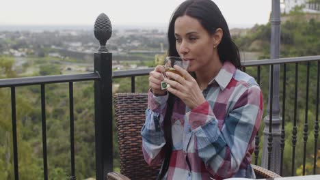 mujer joven sonriente relajándose al aire libre con té