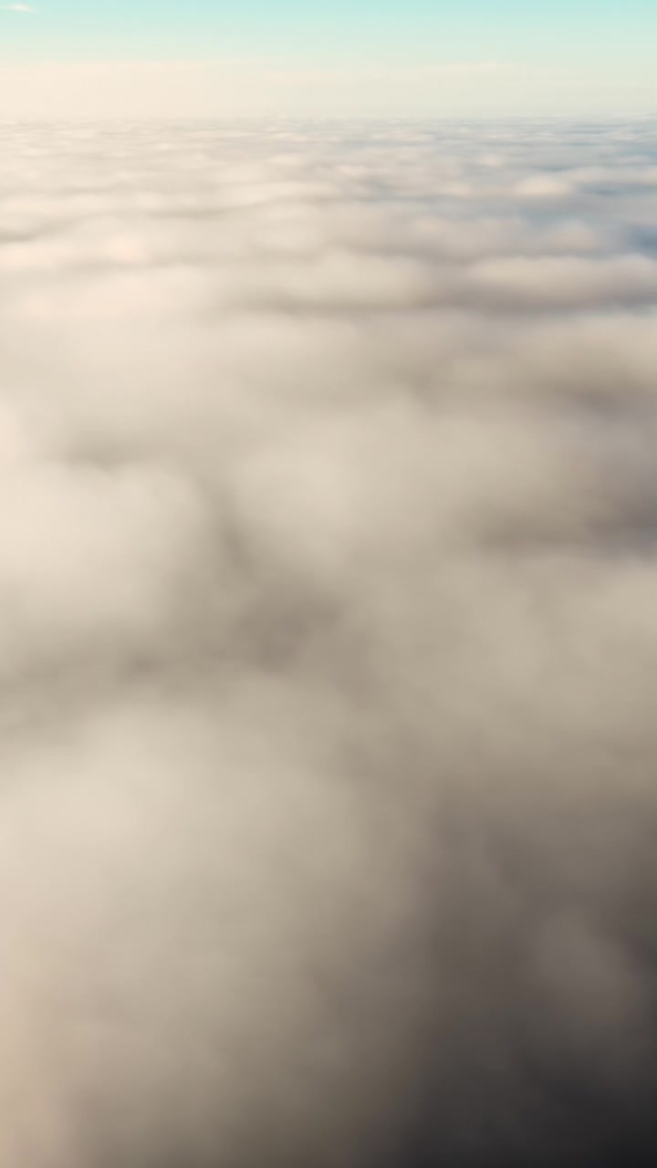 Svævende i luften over bløde hvide skyer med en blegblå himmel, et drømmende skylandskab set ovenfra, der skaber en fredfyldt atmosfære