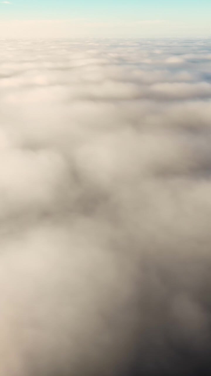 Svævende i luften over bløde hvide skyer med en blegblå himmel, et drømmende skylandskab set ovenfra, der skaber en fredfyldt atmosfære