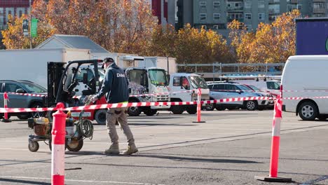 worker using machinery in a parking lot