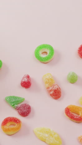 video of colourful jelly candy and jar on pink background