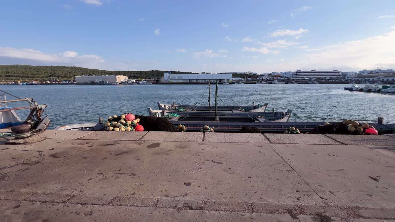 Boats are moored in the harbor under sunny weather