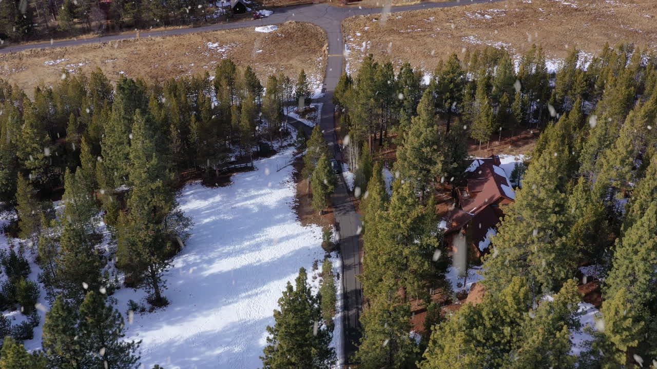 vehículo saliendo de una casa moderna en el bosque durante las nevadas cerca de la orilla del lago, vista aérea
