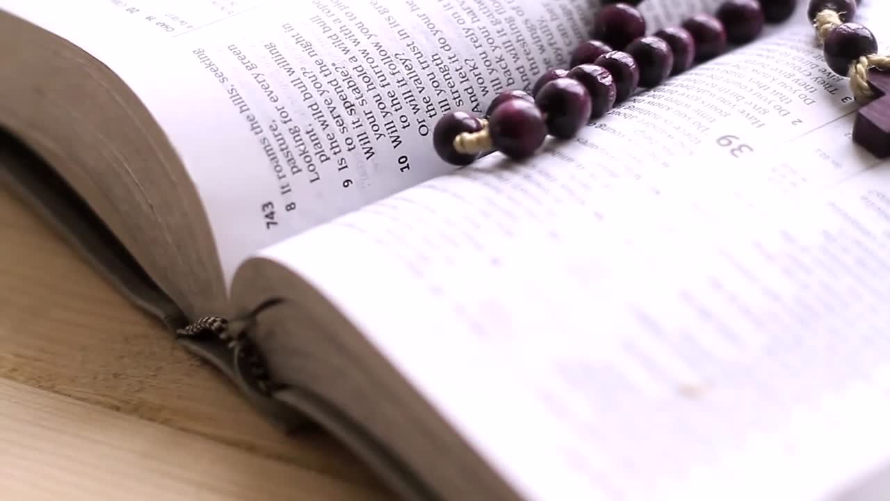 praying to God with cross on bible on table with no people stock video