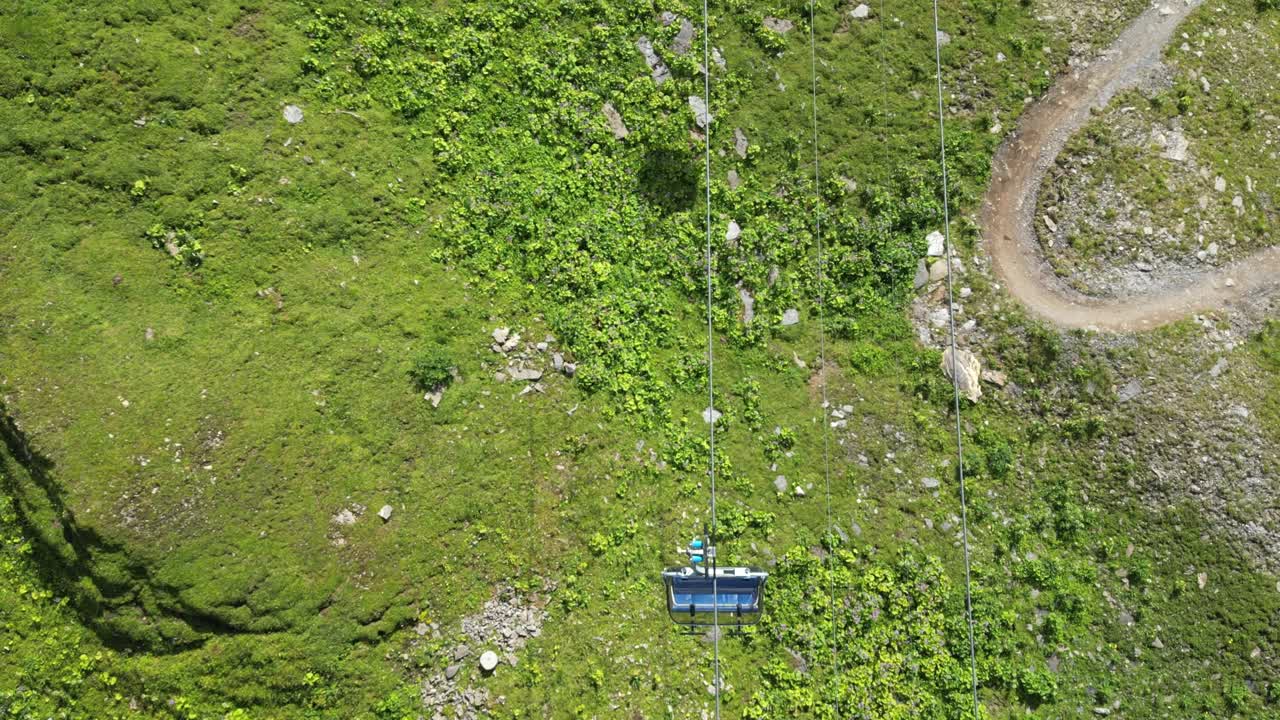 inclinar hacia abajo, vista aérea de drones de un teleférico bajando la montaña, alpes suizos durante el verano, engelberg, obwalden