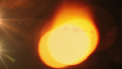 glóbulo naranja brillante de luz y punto de luz contra un fondo negro