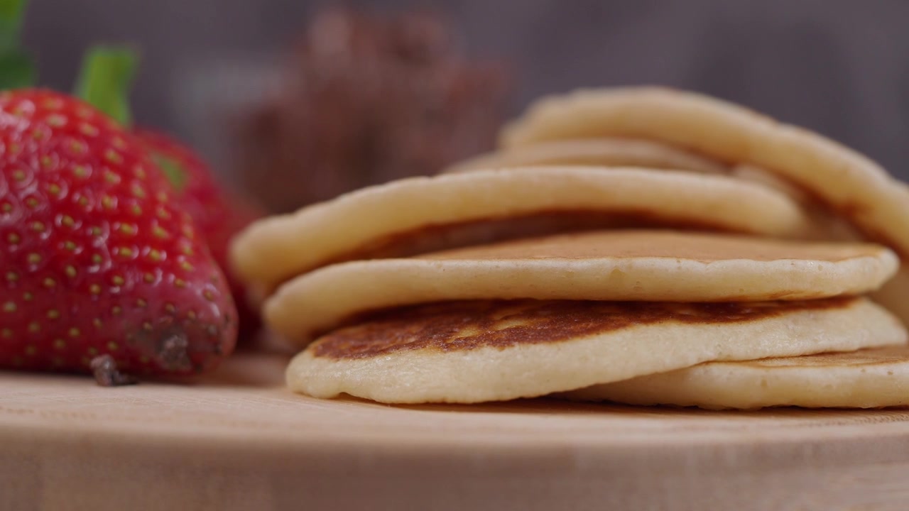 Stack of Fresh Pancakes with Strawberries on a Wooden Board