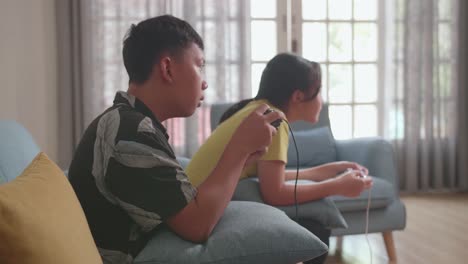 teenagers playing video games on a couch