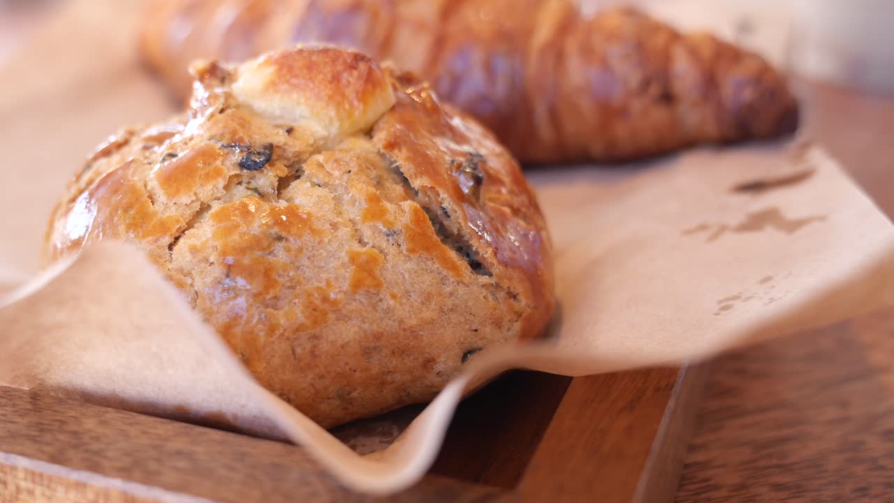 pasteles deliciosos y croissants en una bandeja de madera