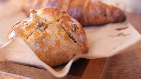 pasteles deliciosos y croissants en una bandeja de madera
