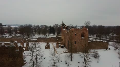 ruins of ancient livonian order's stone medieval castle latvia aerial drone top shot from above . restored castle capella at winter in dobele city. 4k resolution