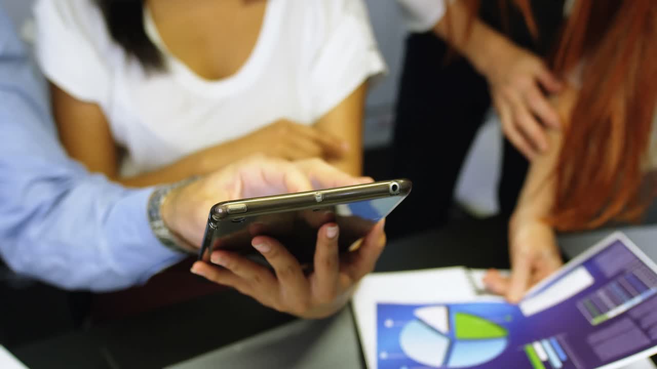 colegas de negocios discutiendo sobre una tableta digital 4k