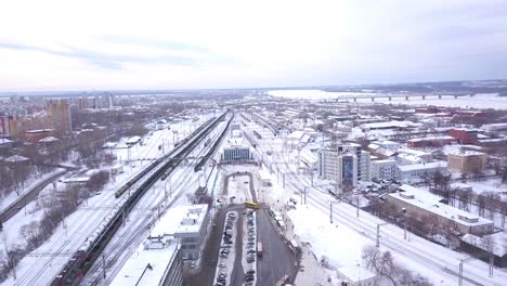 aerial view of a city covered in snow with train station and river