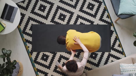 Black-Man-Practicing-Yoga-with-Assistance-of-Wife