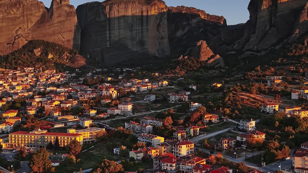 Vista di Meteora al tramonto con edifici e scogliere in Grecia