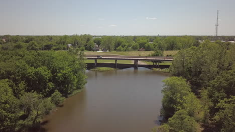 aerial over water looking ahead to four lane bridge