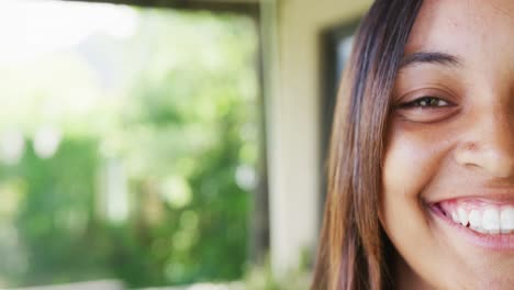 Portrait-of-a-happy-biracial-teenager-girl-at-home,-slow-motion