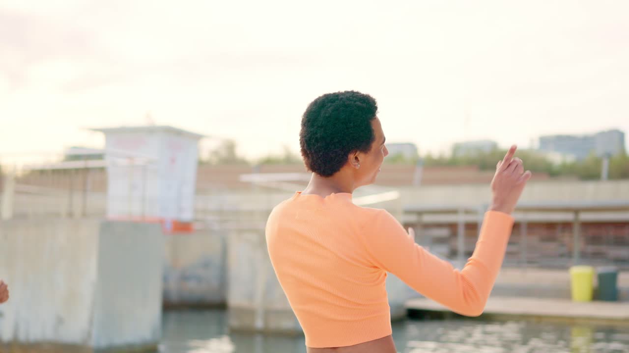 Multi-ethnic friends dancing happily during sunset next to the sea