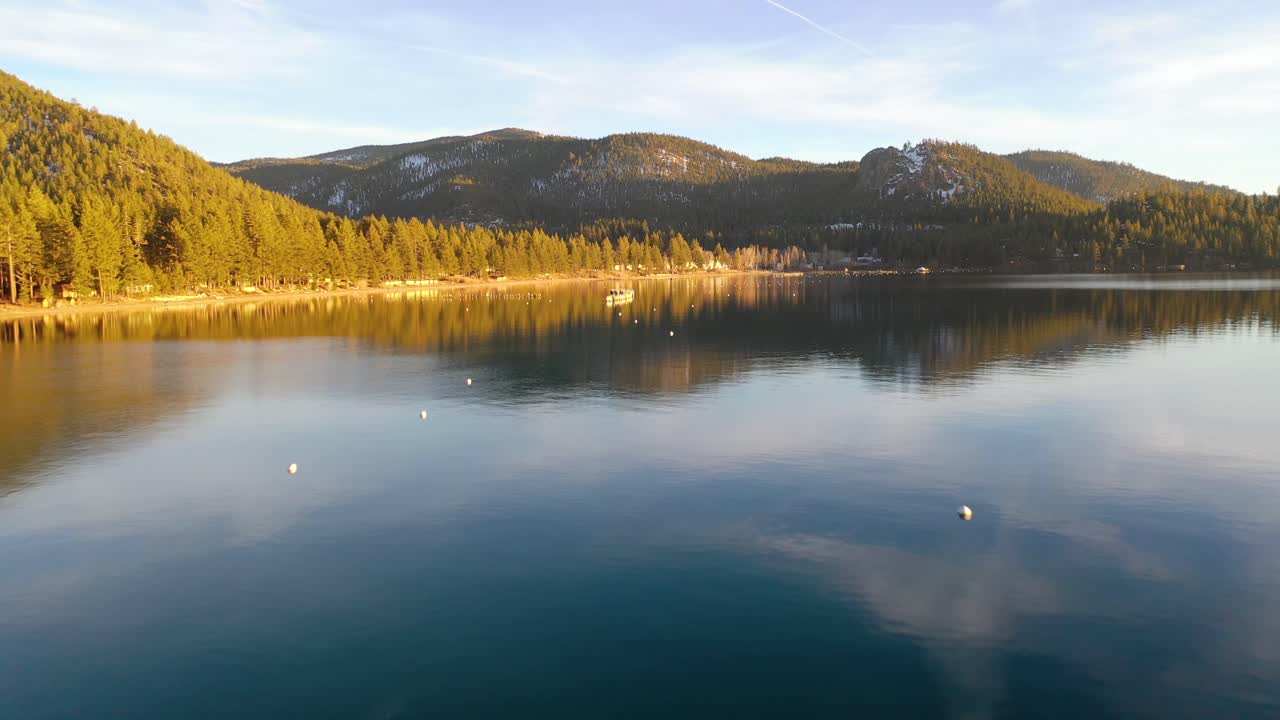 вечерний закат солнца с дрона над гленбруком, озеро тахо, штат невада, со старыми сваями пирса, выходящими из спокойной воды