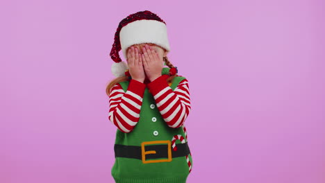 Girl-kid-toddler-Santa-Christmas-Elf-fooling-around-having-closing-eyes-with-hand-and-spying-through