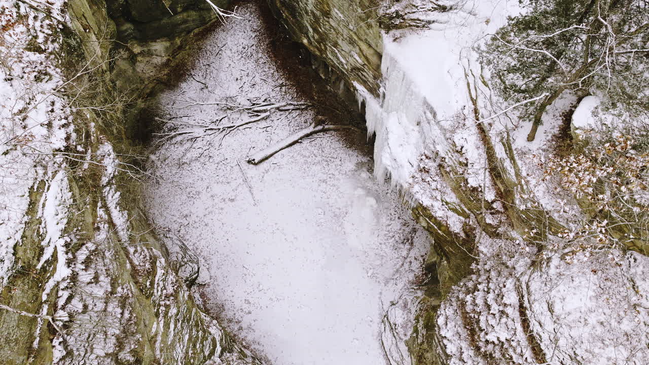 video de avión no tripulado del área del parque estatal de starved rock en invierno con nieve cayendo