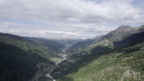 Drone-video-of-frontal-plane-moving-down-over-the-Vermosh-valley-above-the-Vermoshi-river,-the-sh20-at-the-height-of-Bashkimi,-Albania