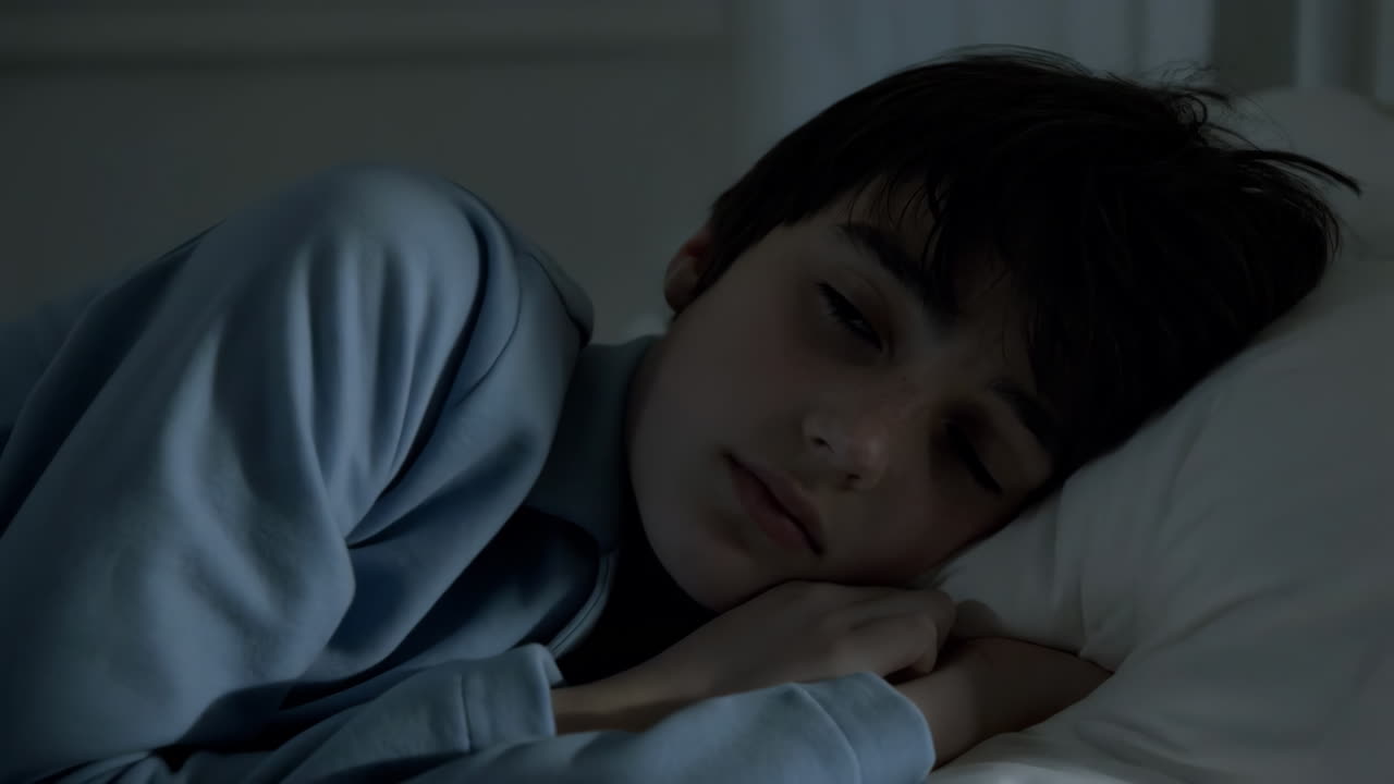 A young boy sleeping peacefully in bed at night