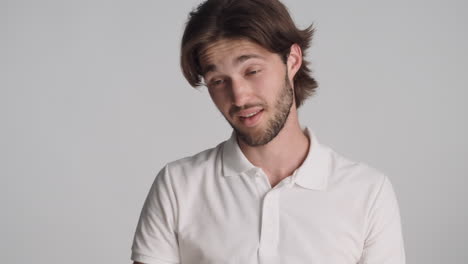 caucasian tired man in front of camera on gray background.