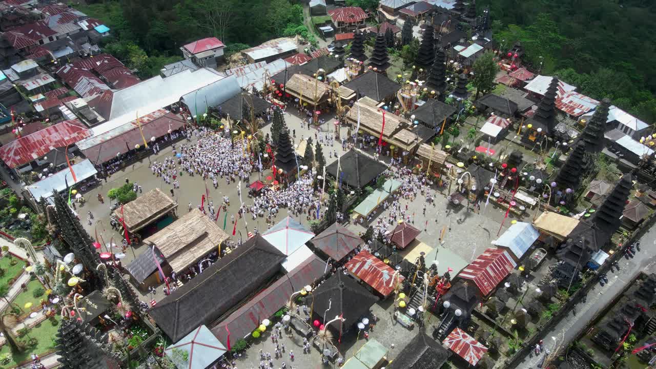Close-up kelompok besar peserta yang berkumpul untuk upacara Hindu religius Bali selama ritual Melasti di sebuah pura bernama Pura Tuluk Biyu dekat Gunung Batur.